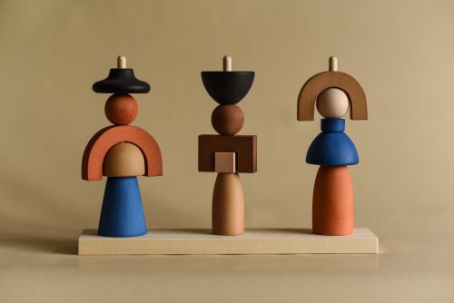 Triple wooden stacking toy that forms dolls. It has earth colors and blue for contrast.